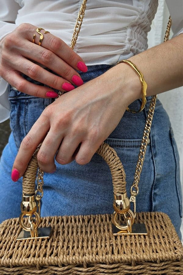 Modische gewebte Tasche mit Handgriff in Korbform und eckigem Design. Ausgestattet mit Drehverschluss, goldenen Details und abnehmbarer goldener Schulterkette. Leichte, komfortable Damenhandtasche, die als Handtasche oder Umhängetasche getragen werden kann. Der lässige Stil und das zarte, einzigartige Design machen sie zum perfekten Begleiter für den Alltag und zu einem echten Blickfang.