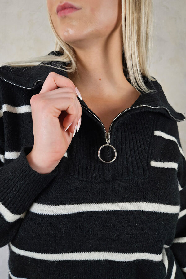Gentle Comfort Stripes Kleid in Schwarz: Ein weiches Strickkleid mit eleganten Streifen. Es bietet eine Mini-Länge und einen vielseitigen Stehkragen mit Reißverschluss, der auch als V-Ausschnitt getragen werden kann. Die Rippbündchen an Ärmeln und Saum sorgen für bequemen und hochdehnbaren Tragekomfort