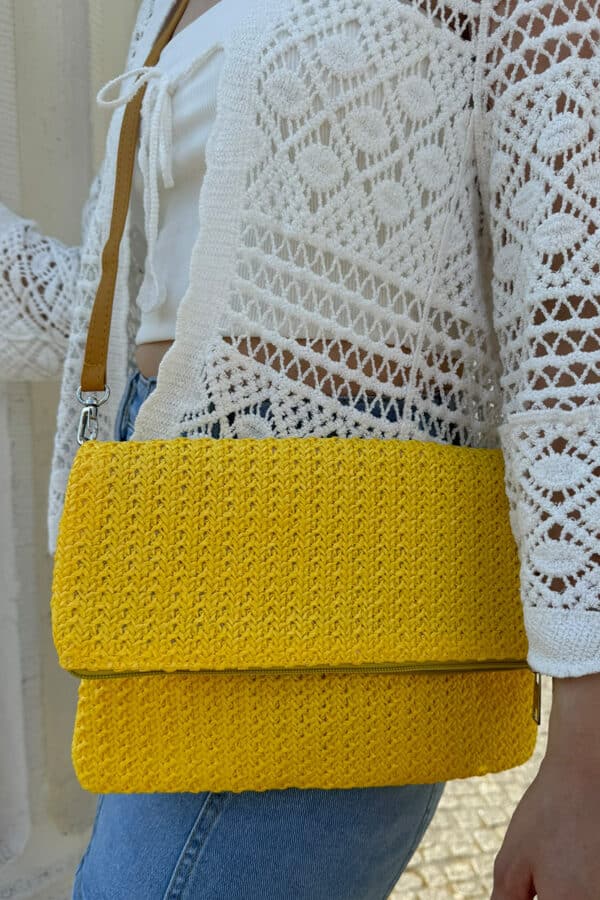 Sommerliche geflochtene Clutch-Tasche mit stilvollem Flechtdesign in gelb. Die Tasche verfügt über einen sicheren Reißverschluss und zusätzlichen Magnetverschluss. Dank des abnehmbaren und verstellbaren Schulterriemchens kann sie flexibel als Clutch oder Umhängetasche getragen werden. Leichtes, modisches Accessoire für Alltag, Urlaub und sommerliche Outfits.