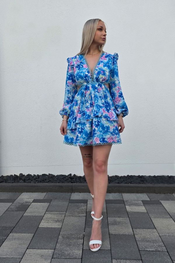 Sommerliches Minikleid mit floralem Muster in Blau- und Rosatönen, kurzem A-Linien-Rock und tiefem V-Ausschnitt für eine feminine Silhouette. Lange Puffärmel mit elastischen Bündchen sorgen für luftigen Tragekomfort. Seitliche Cut-outs und ein offener Rücken mit zarten gehäkelten Spitzeneinsätzen verleihen dem Kleid eine verspielte Boho-Note. Der stufige Volant-Rock und die kurze Passform machen das Kleid ideal für warme Tage und lässige Sommerlooks.