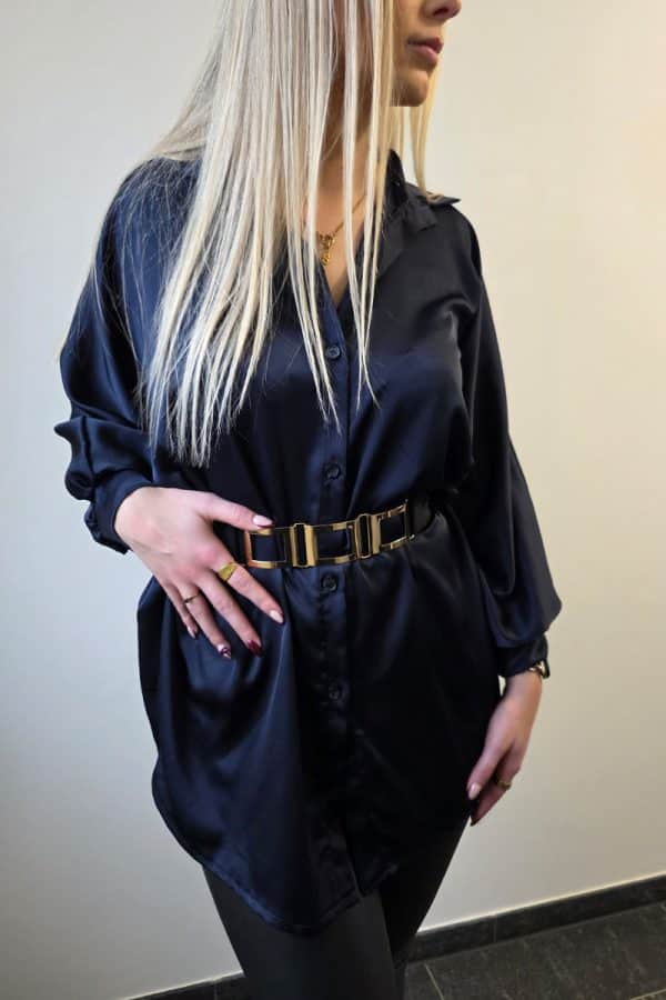 Dunkelblaue Oversize Damenbluse aus weich fließendem, leicht glänzendem Stoff. Die Bluse hat lange Fledermausärmel, eine klassische Knopfleiste vorne und einen dezenten Stehkragen. Der verlängerte, abgerundete Saum am Rücken sorgt für einen modernen, eleganten Look. Ideal für Büro, Alltag oder festliche Anlässe, mit lockerer Passform für maximalen Tragekomfort.