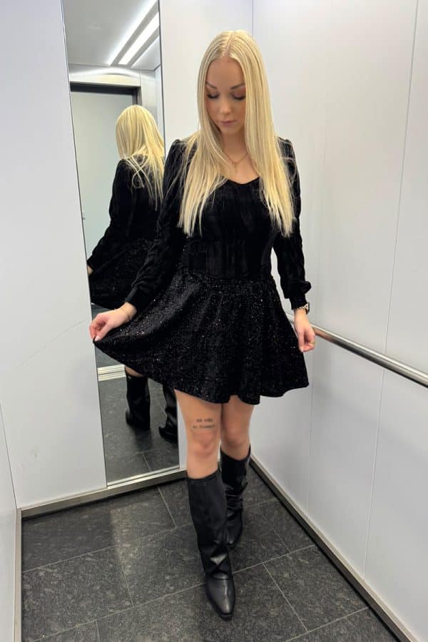 Schwarzer Paillettenrock aus weichem Samt für Damen, mit intensiv funkelnder Glitzeroberfläche und elastischem Bund. Festlicher Minirock im A-Linien-Schnitt, ideal als Partyrock, Glitzerrock oder eleganter Rock für besondere Anlässe. Der Rock besitzt eingenähte Shorts für Sichtschutz und maximalen Tragekomfort.