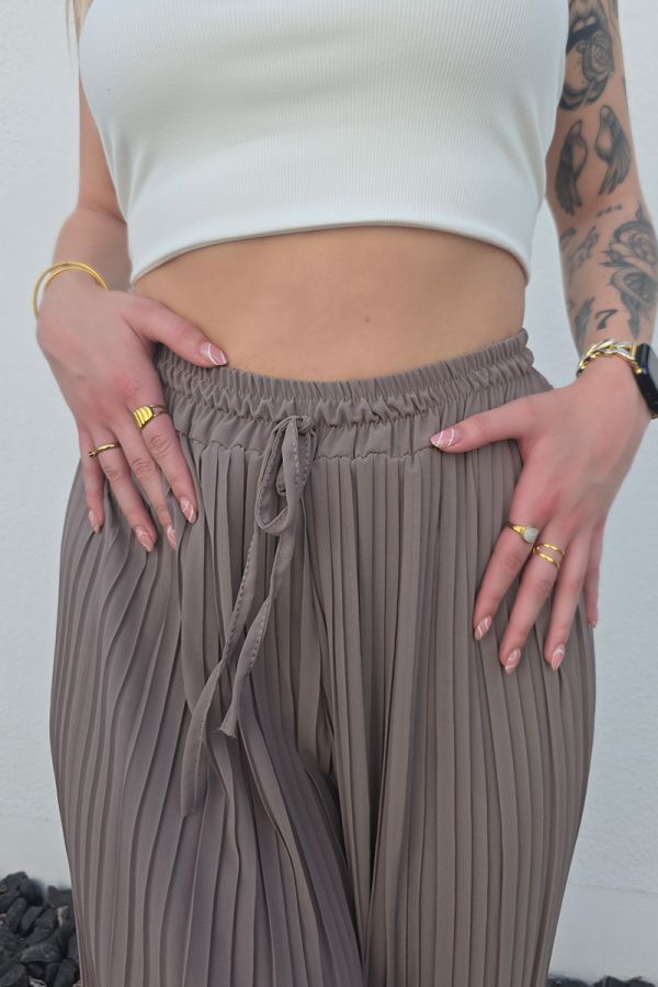 Lässige Plissee-Hose in taupe mit High Waist Schnitt und weitem Bein. Die Hose hat einen Gummizug mit Band an der Taille für eine bequeme Passform. Sie ist mit einer langen, eingenähten Unterhose ausgestattet, die blickdicht ist. Der luftige Stoff macht die Hose ideal für Frühling und Sommer.