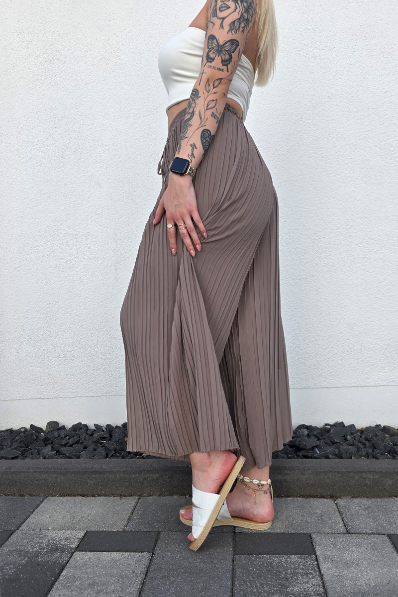 Lässige Plissee-Hose in taupe mit High Waist Schnitt und weitem Bein. Die Hose hat einen Gummizug mit Band an der Taille für eine bequeme Passform. Sie ist mit einer langen, eingenähten Unterhose ausgestattet, die blickdicht ist. Der luftige Stoff macht die Hose ideal für Frühling und Sommer.