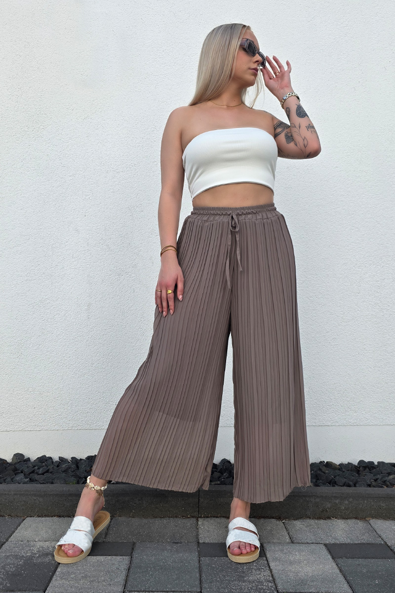 Lässige Plissee-Hose in taupe mit High Waist Schnitt und weitem Bein. Die Hose hat einen Gummizug mit Band an der Taille für eine bequeme Passform. Sie ist mit einer langen, eingenähten Unterhose ausgestattet, die blickdicht ist. Der luftige Stoff macht die Hose ideal für Frühling und Sommer.