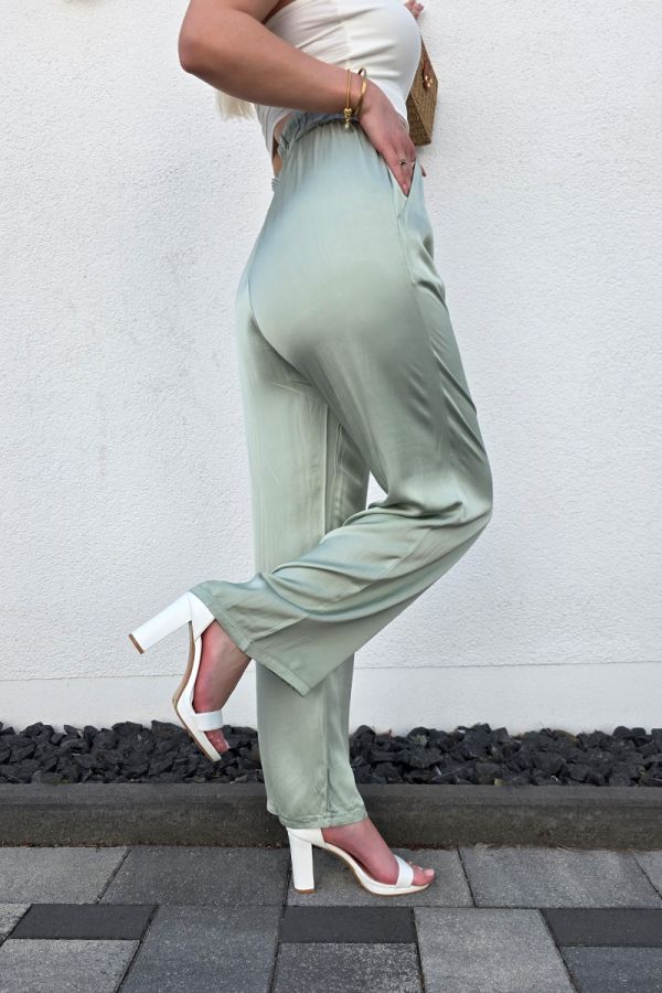 Diese edle Hose in Satin-Optik in einem eleganten Olivton überzeugt mit einem hohen, elastischen Paperbag-Bund und einem lockeren, weiten Schnitt, der luftig und bequem sitzt. Seitliche Eingrifftaschen sorgen für praktische Details, während das fließende Material einen femininen Look unterstreicht. Ideal kombinierbar mit einem Bandeau-Top und Sandaletten für einen lässig-eleganten Casual Chic Style.
