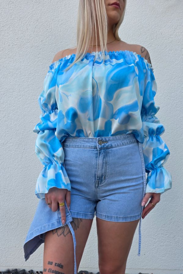 Stilvoller Jeans Skort im Wickel-Look aus hellem Denim-Blau mit seitlicher Schleife zum Binden, integriertem Reißverschluss und Metallknopf. Der Skort verfügt über praktische Hosentaschen hinten und eine kurze Innenhose für maximalen Komfort und volle Bewegungsfreiheit – perfekt für Citytrips, Festivals oder entspannte Tage am Strand.