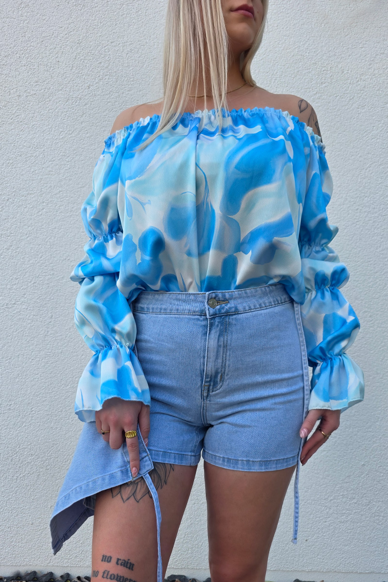 Stilvoller Jeans Skort im Wickel-Look aus hellem Denim-Blau mit seitlicher Schleife zum Binden, integriertem Reißverschluss und Metallknopf. Der Skort verfügt über praktische Hosentaschen hinten und eine kurze Innenhose für maximalen Komfort und volle Bewegungsfreiheit – perfekt für Citytrips, Festivals oder entspannte Tage am Strand.