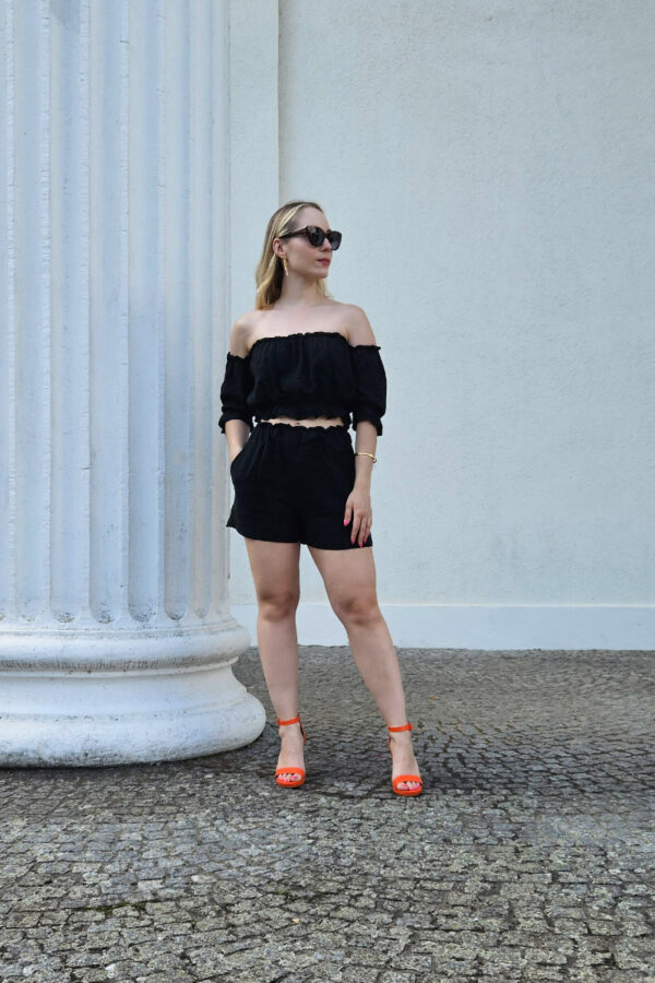 Das Sweet Summer Delights Se in schwarzt aus luftigem Baumwollstoff. Das Set besteht aus einem Off-Shoulder Crop Top mit elastischem Saum und Rüschen sowie ¾ Puffärmeln. Dazu gehören High Waist Shorts mit Seitentaschen und einem elastischen Bund, die für eine bequeme Passform sorgen.