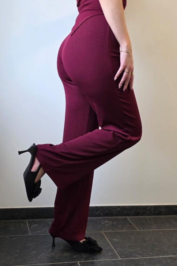 Weinrotes Damen Zweiteiler Set mit asymmetrischem Bandeau-Top aus geripptem, weich fließendem Stoff und passender High-Waist Palazzo-Hose mit weitem, eleganten Schnitt – ideal für Partys und Abendlooks.